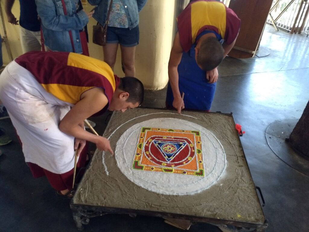 Monaci tibetani al lavoro su un mandala di sabbia: al termine della cerimonia verrà cancellato, come insegnamento sull'i